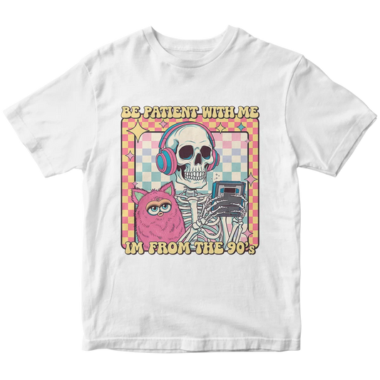 A white t-shirt with a custom DTF print featuring a retro 90s-themed graphic. The design shows a skeleton with headphones and a fluffy pink creature, with the text 'BE PATIENT WITH ME I'M FROM THE 90'S.' This showcases vibrant and durable custom t-shirt printing for nostalgic apparel in Miami.