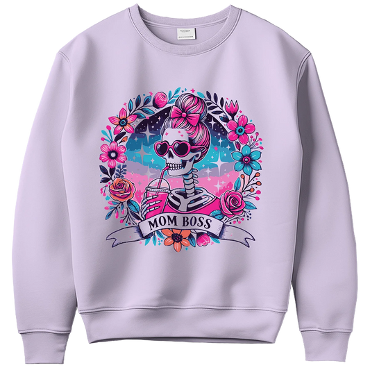 A light purple sweatshirt with a custom DTF print of a skeleton with a pink bow and sunglasses drinking from a straw. The design is framed by a floral wreath and a banner with 'MOM BOSS', showcasing high-quality DTF printing for personalized clothing in Miami.