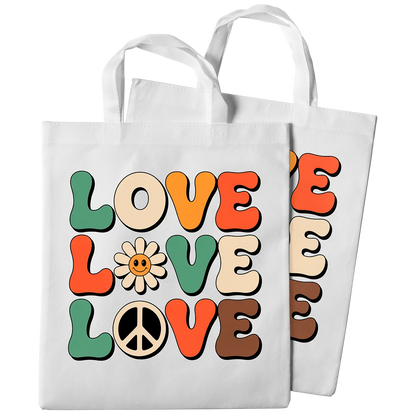 A pair of white tote bags with a custom DTF print. The design features the word 'LOVE' repeated three times in a retro, groovy font, with a smiling daisy and a peace sign. This showcases high-quality DTF printing for custom tote bags and merchandise in Miami.