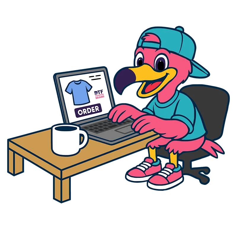 Pink flamingo mascot sitting at a desk with a coffee mug, using a laptop to place a custom DTF transfer order. Represents the easy online ordering process for high-quality apparel prints.